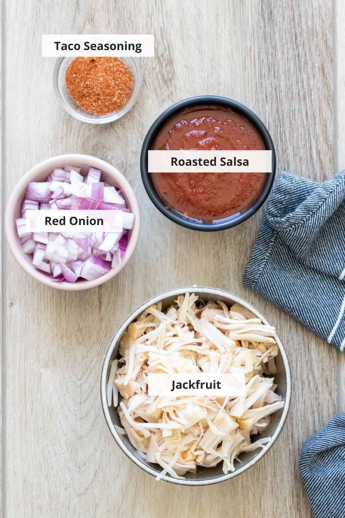 Ingredients for vegan jackfruit tacos recipe on a wood background.