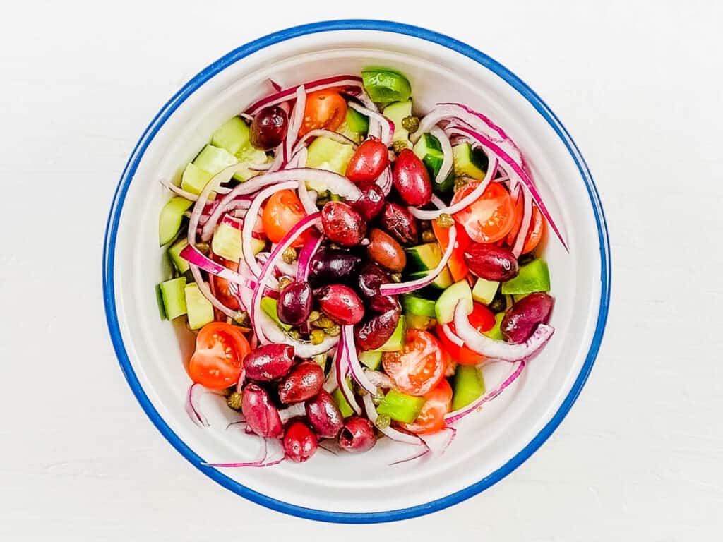 Greek keto chopped salad in a mixing bowl.