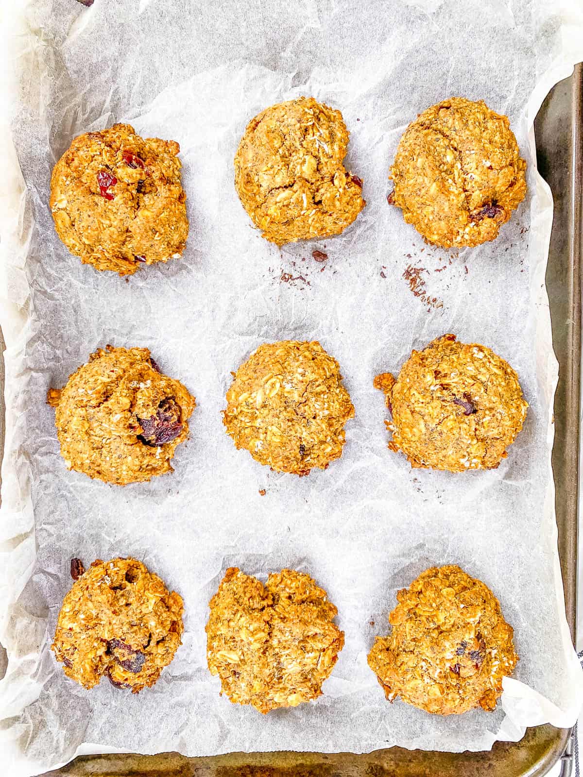Low sugar vegan breakfast cookies on a baking sheet lined with parchment paper.