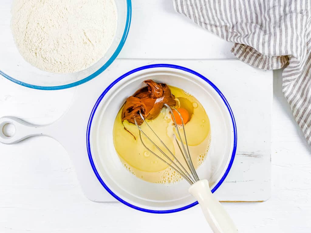 Wet ingredients for waffle batter in a mixing bowl.