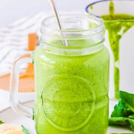Easy spinach and banana smoothie with peanut butter served in a mason jar glass with a straw.