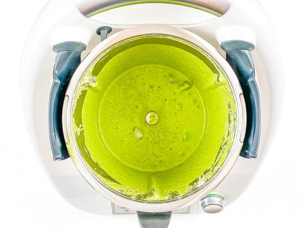 Banana and spinach smoothie blended in a blender (top view).