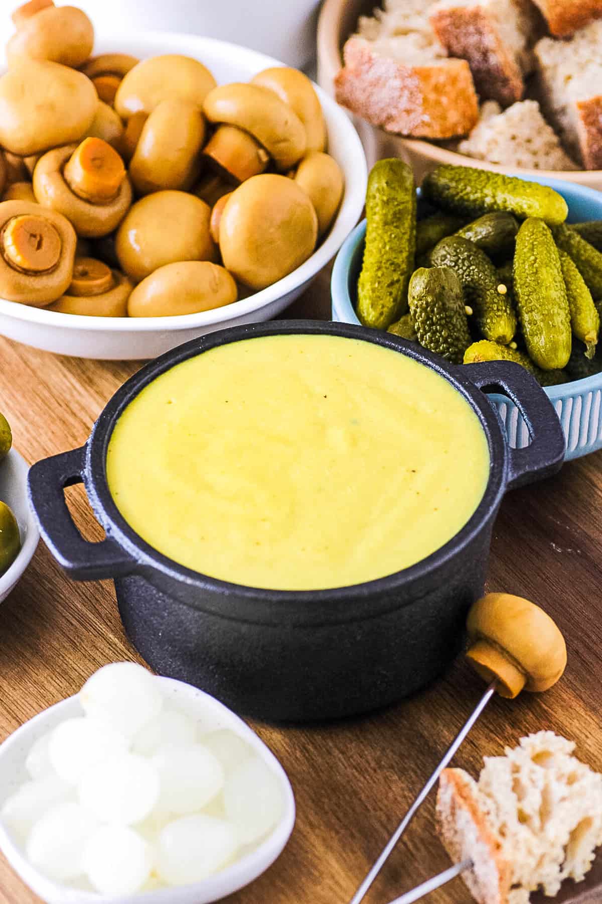 Vegan fondue, served in a fondue pot with veggie dippers on the side.