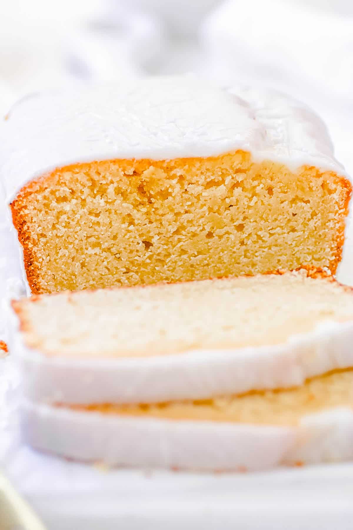 Vegan pound cake, sliced and served on a white cutting board.