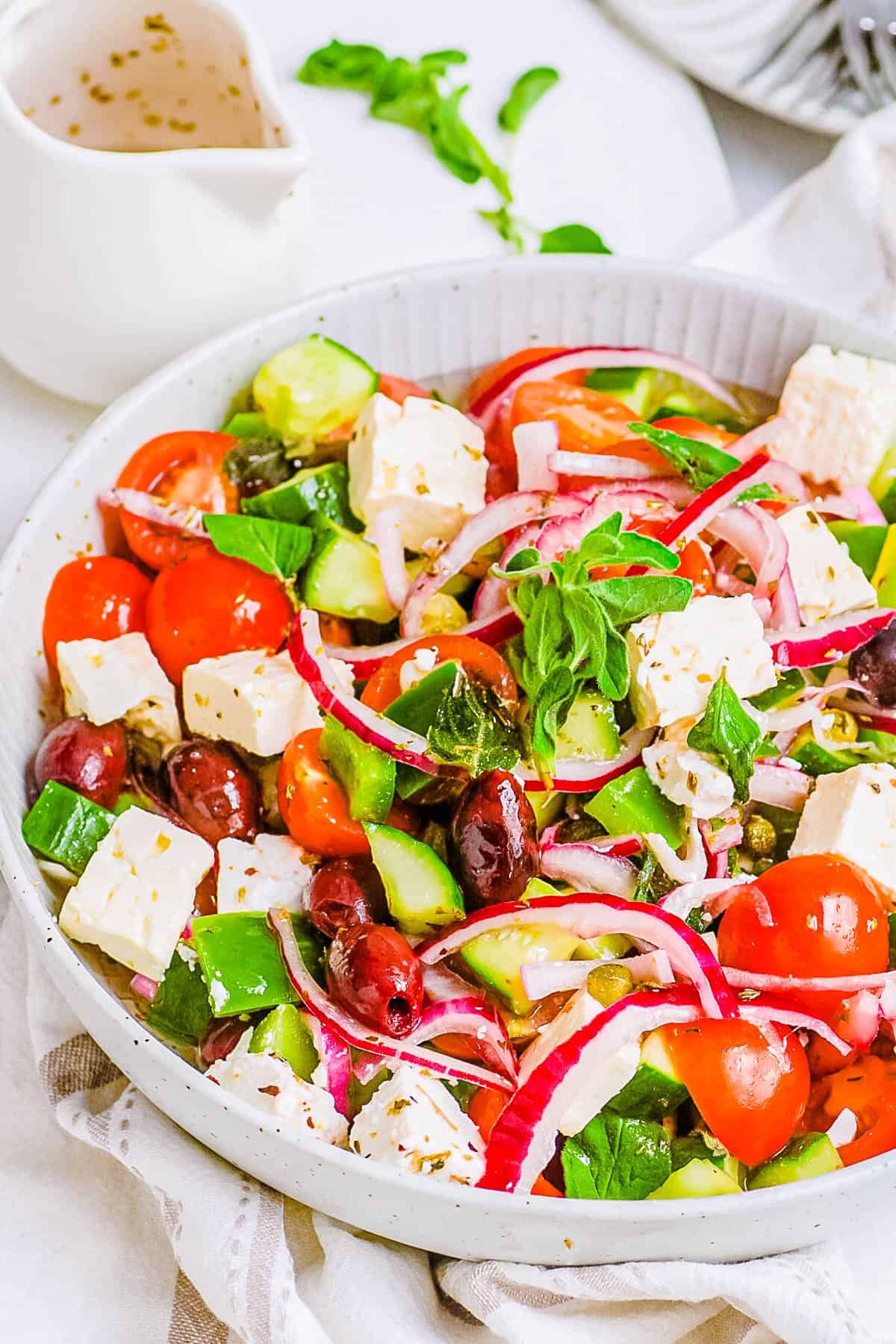 Low carb keto Greek salad with feta served in a white bowl.