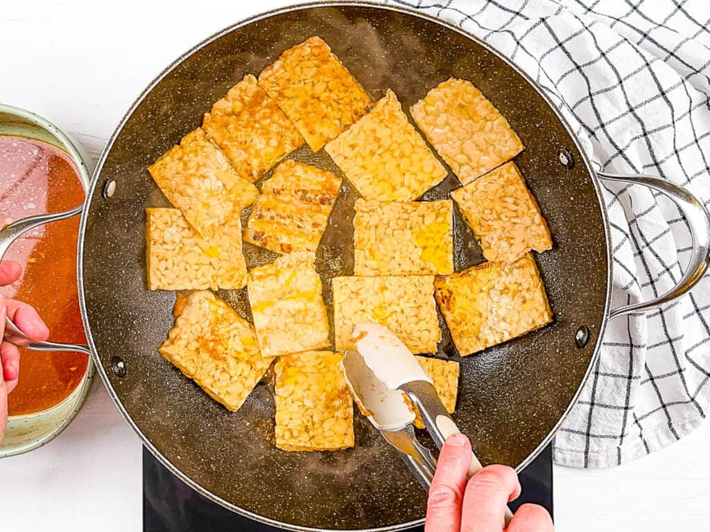 Marinated tempeh cooking in a s،et.