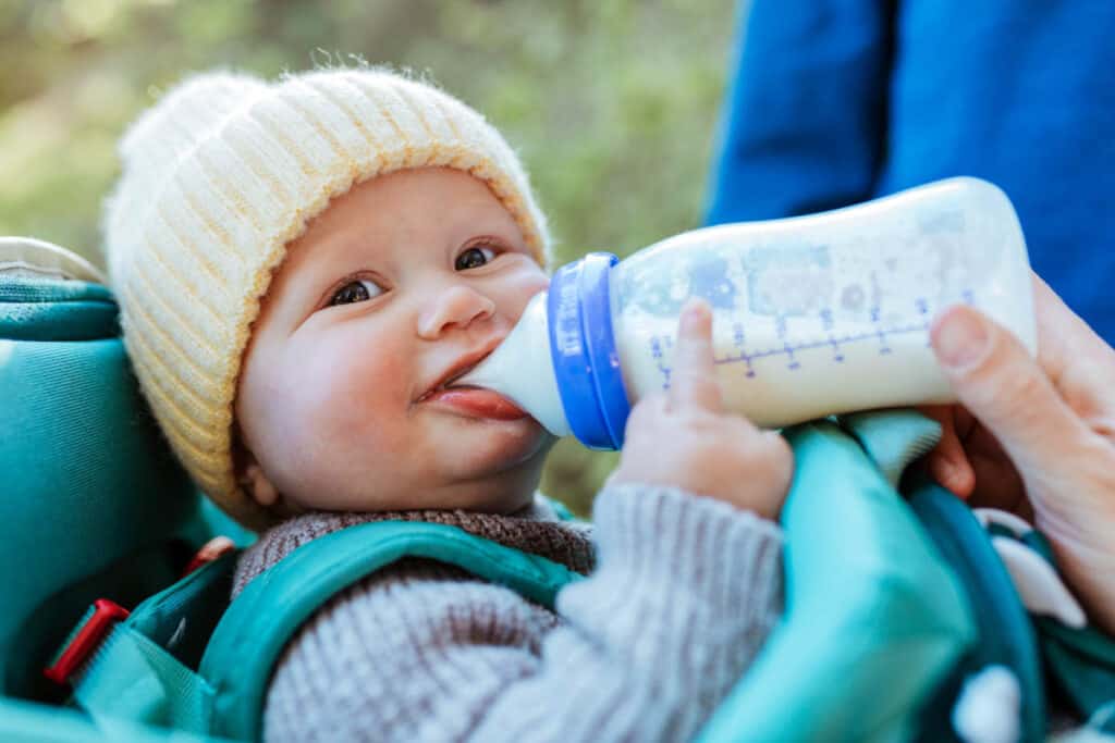 Baby drinking formula from a bottle - transitioning from ، milk to formula.