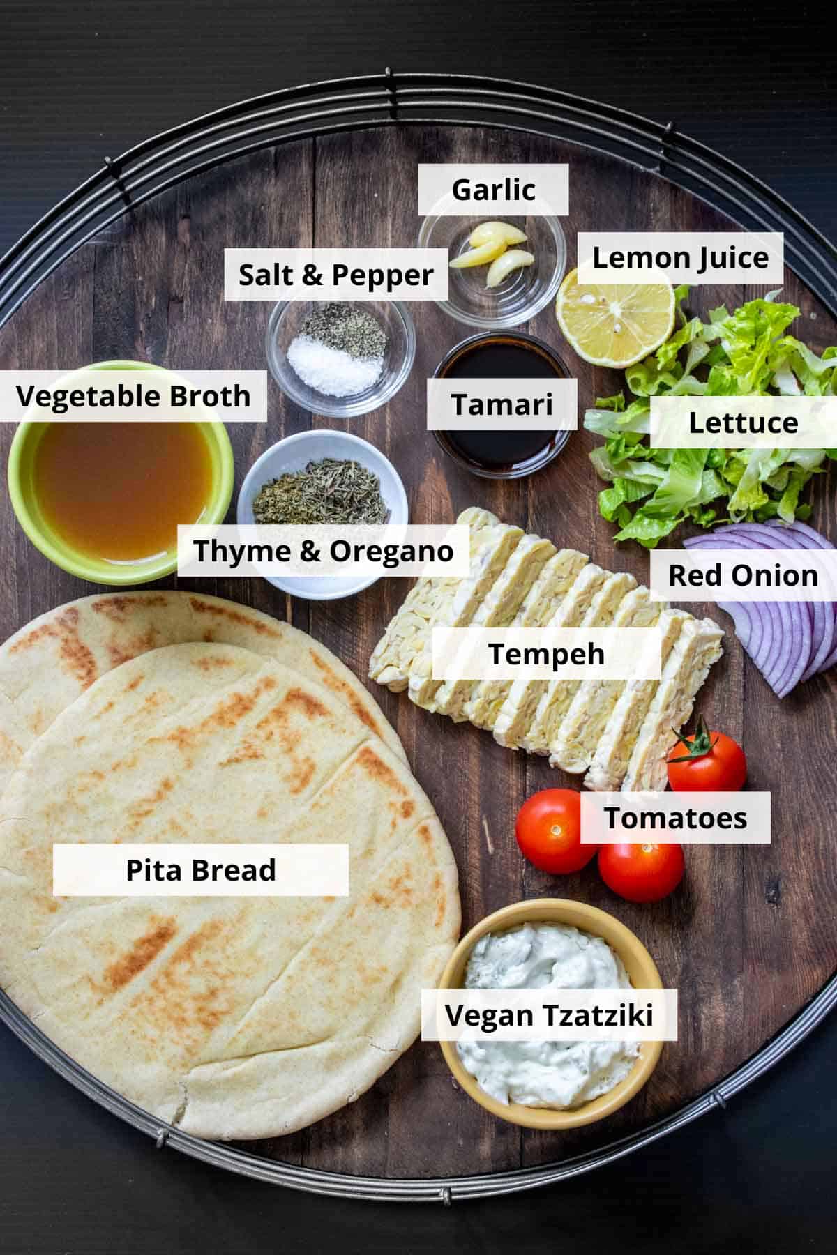 Ingredients for vegan tempeh gyros recipe on a wooden background.