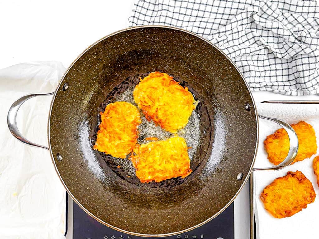 Hash browns like McDonald's being fried in a large pan.