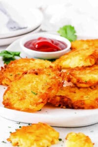 Copycat McDonald's hash browns recipe served on a white plate, with ketchup on the side.