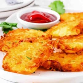 Copycat McDonald's hash browns recipe served on a white plate, with ketchup on the side.