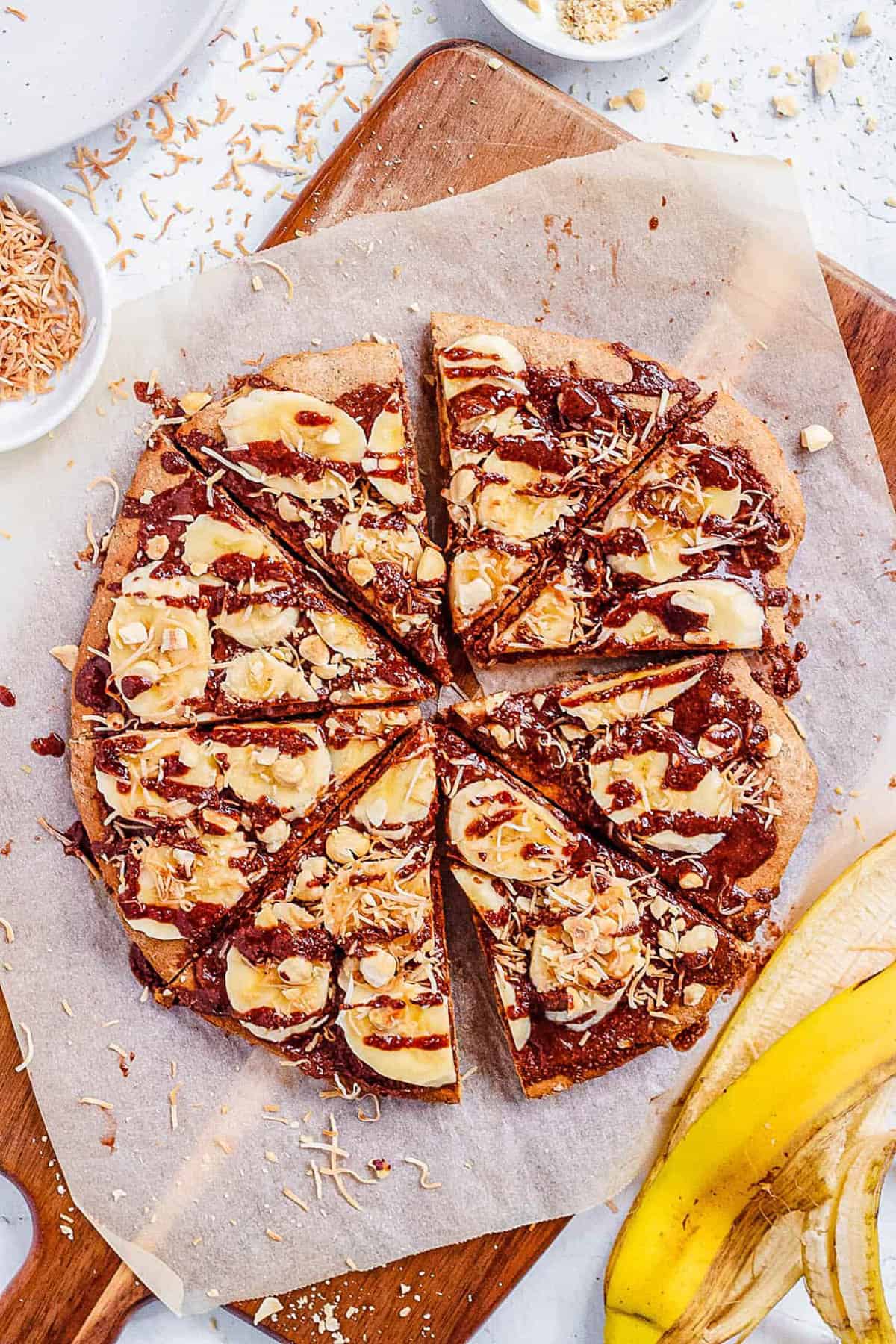 Top view of Nutella pizza with banana (dessert pizza recipe) on parchment paper.
