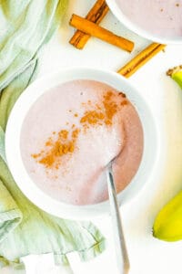 Jamaican banana porridge, served in a white bowl, garnished with a sprinkle of cinnamon on top.