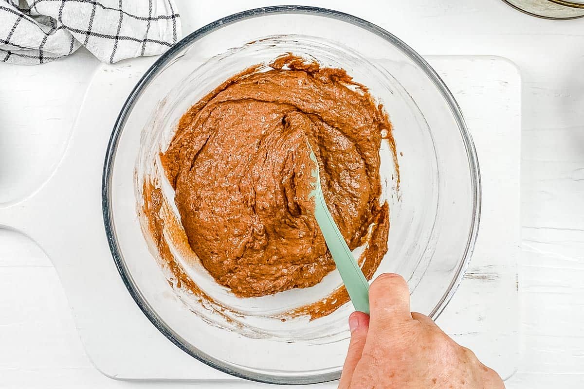 The wet and dry ingredients are mixed together to create a thick cake batter. 