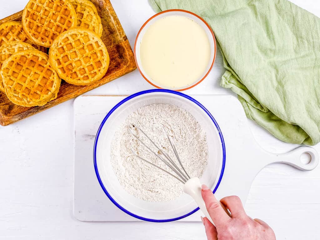 Dry ingredients for waffles mixed in a mixing bowl.