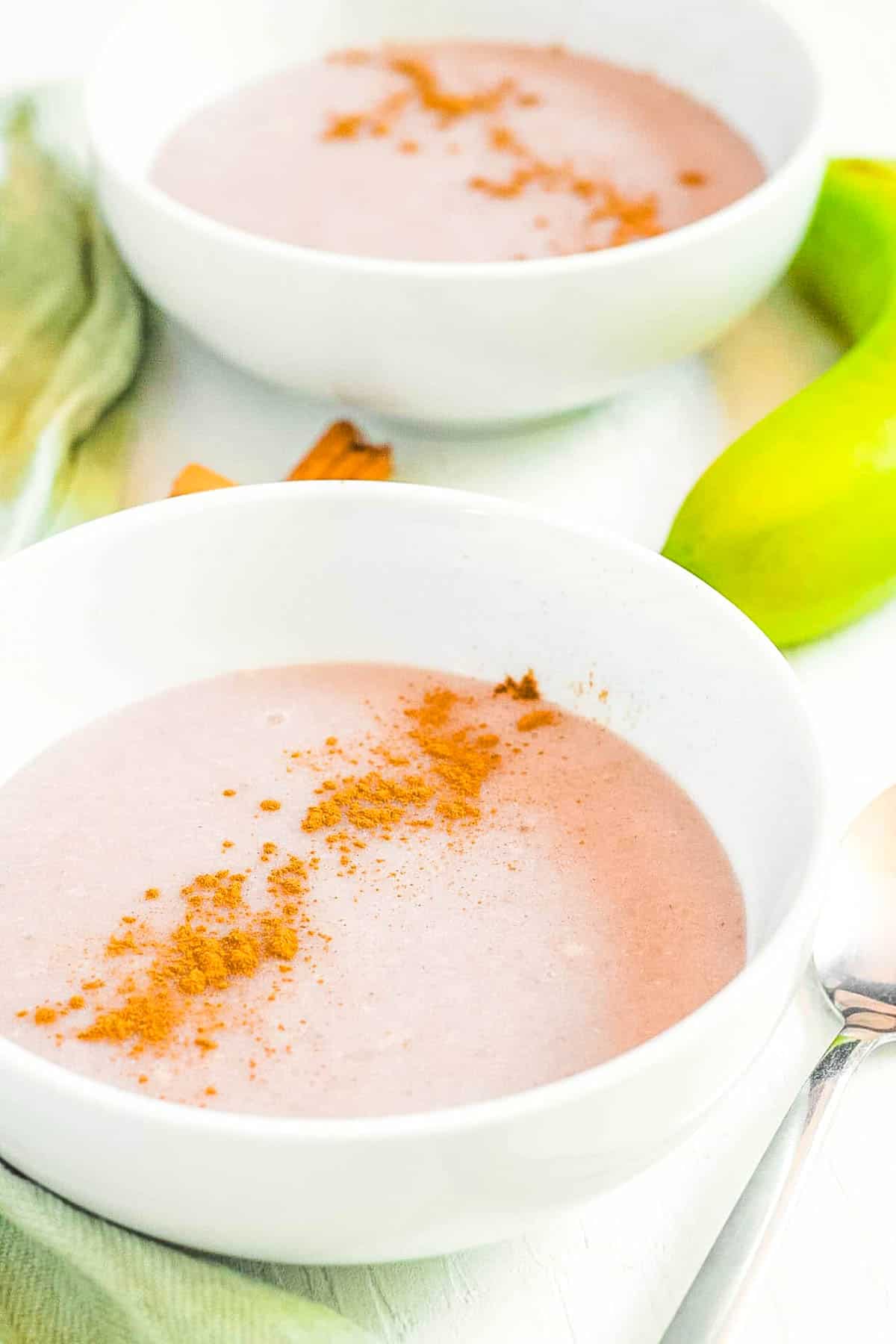 Jamaican banana porridge, served in a white bowl, garnished with a sprinkle of cinnamon on top.