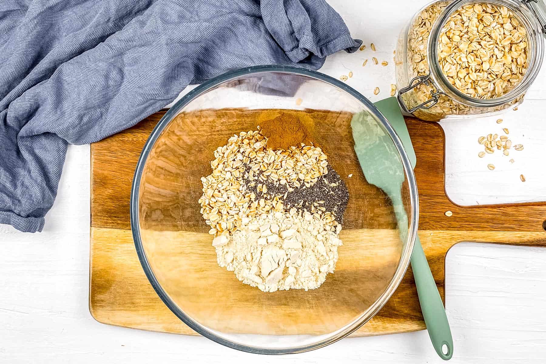Oats, chia seeds, and protein powder added to a large mixing bowl. 