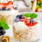Vegan high protein overnight oats served in glasses with fresh berries and mint as a garnish.