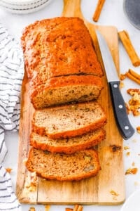 Banana bread without butter sliced on a wooden cutting board.