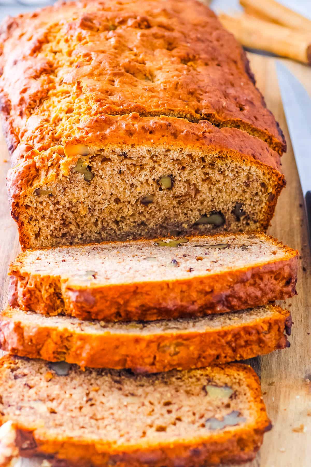 Closeup of banana bread without butter sliced on a wooden cutting board.