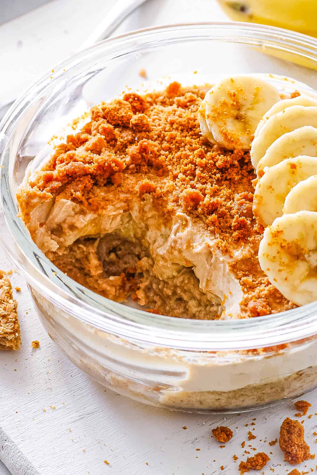 Biscoff overnight Weetabix, topped with sliced bananas, served in a gl، bowl.