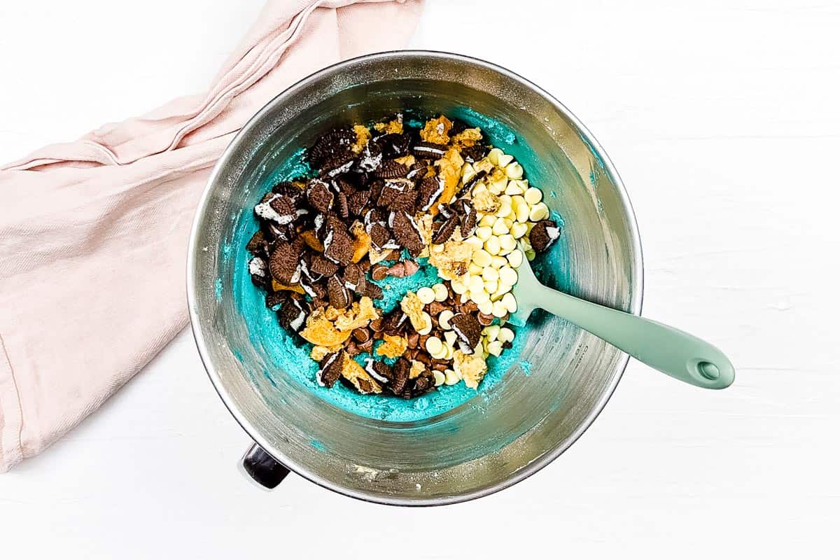 Mix-ins like chopped cookies and chocolate chips are mixed into the blue cookie dough. 