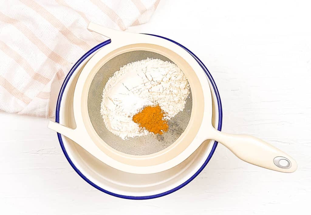 Dry ingredients for cake sifted into a mixing bowl.