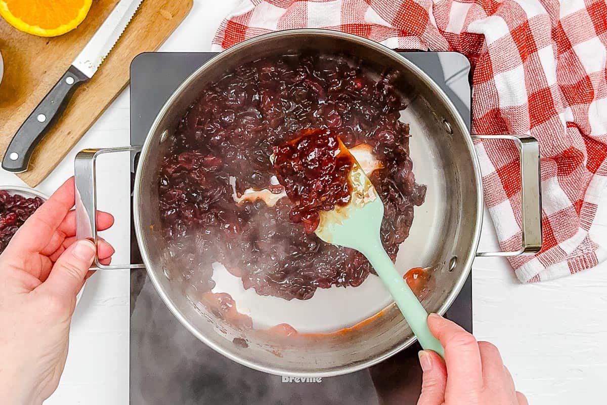 Thickened cranberry sauce on a green spatula.