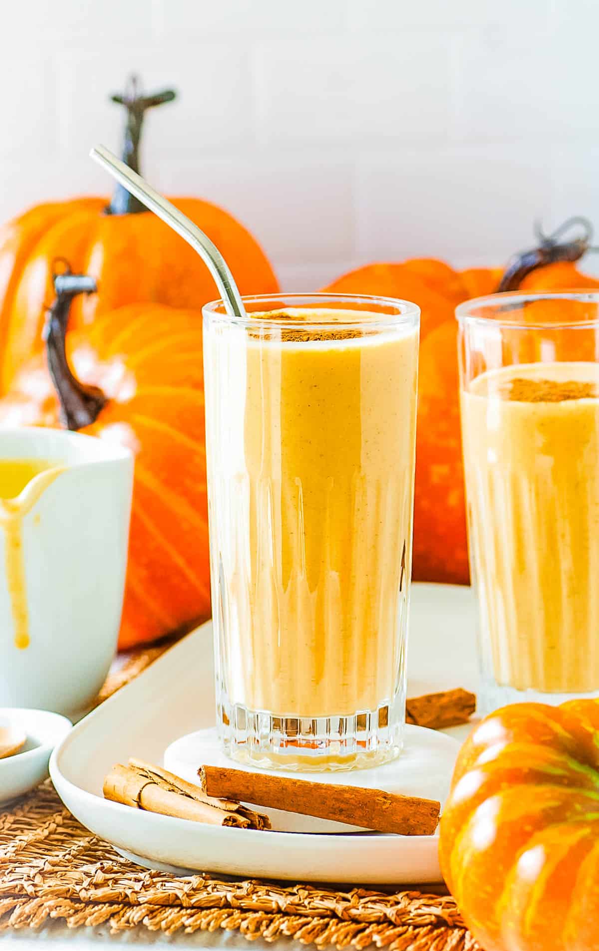 Healthy pumpkin smoothie served in a tall glass with a sprinkle of pumpkin pie spice on top.