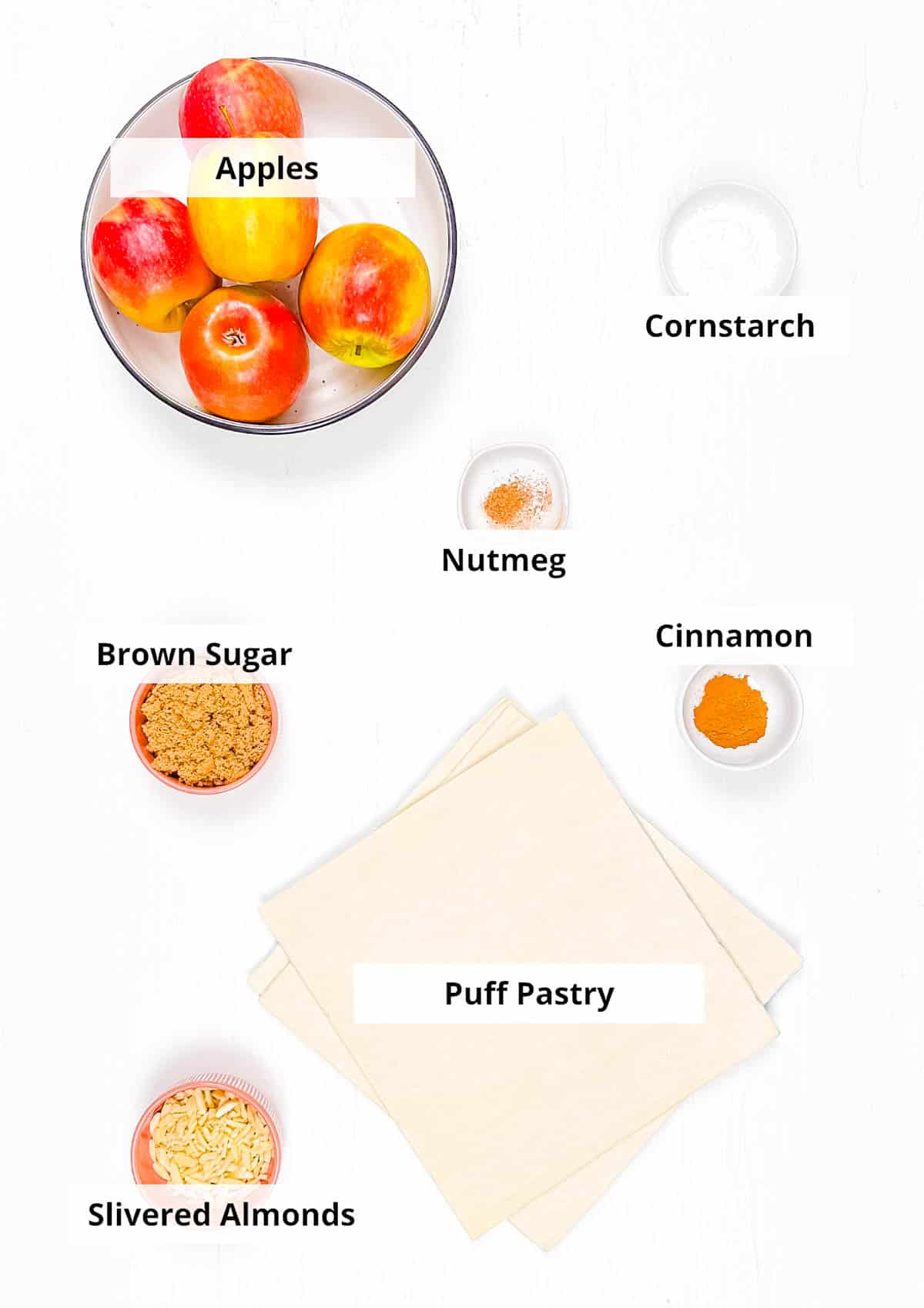 Ingredients for mini apple pies with puff pastry recipe on a white background.