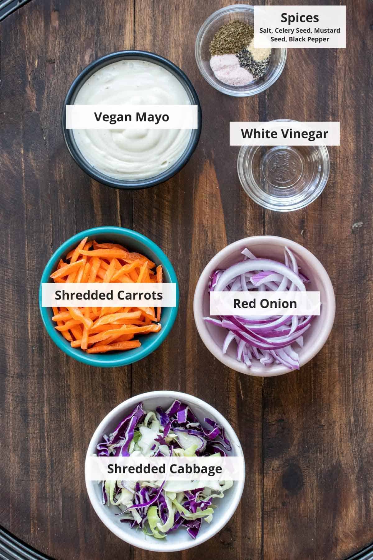Ingredients for vegan coleslaw on a wood background.