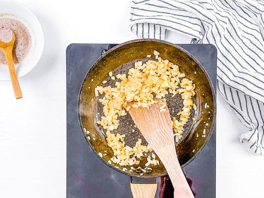 Onions and garlic sauteeing in a pan.