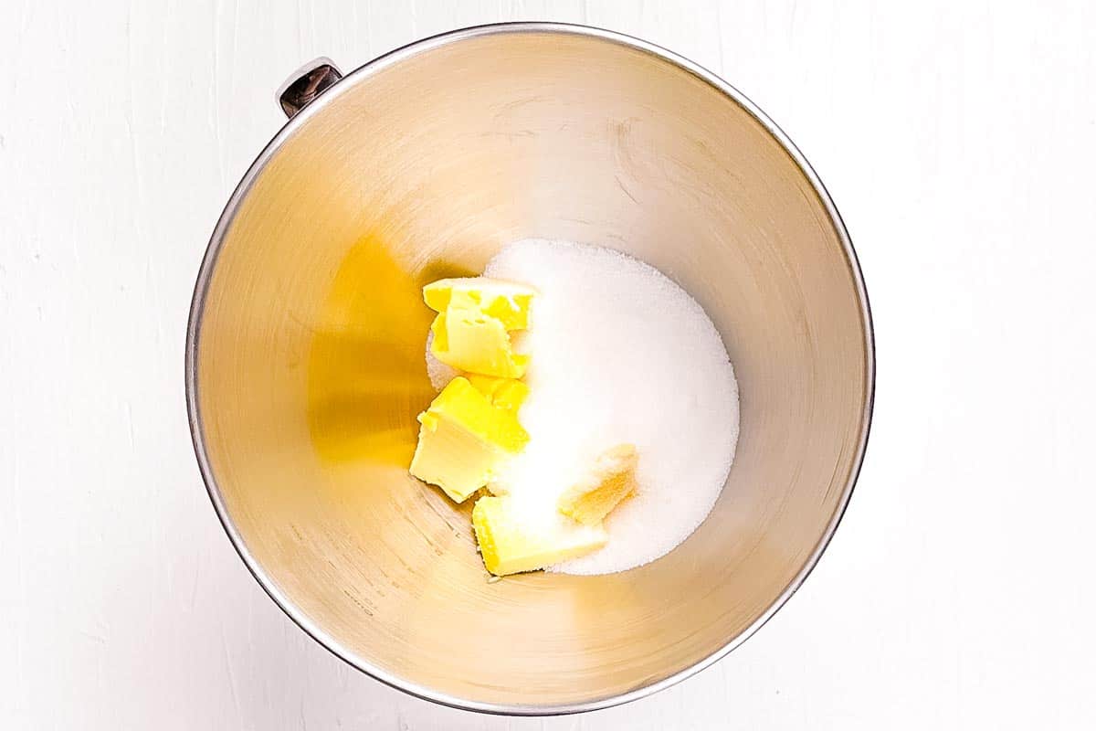 Butter and white sugar in the bowl of a stand mixer before being creamed together.