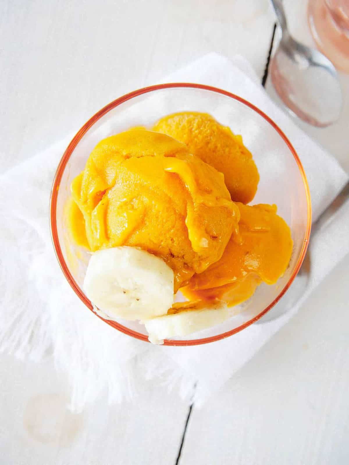 Mango nice cream in a glass serving dish.