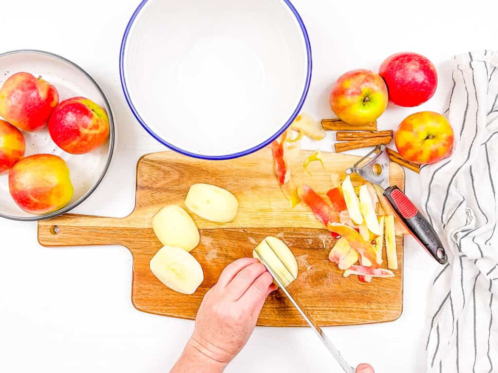 Preparing the apples by coring them, peeling and then chopping into small pieces.