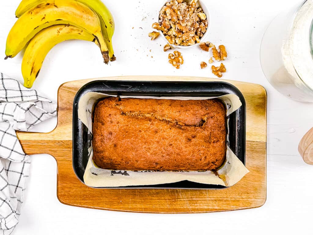 Banana bread with coconut oil baked in a loaf pan.