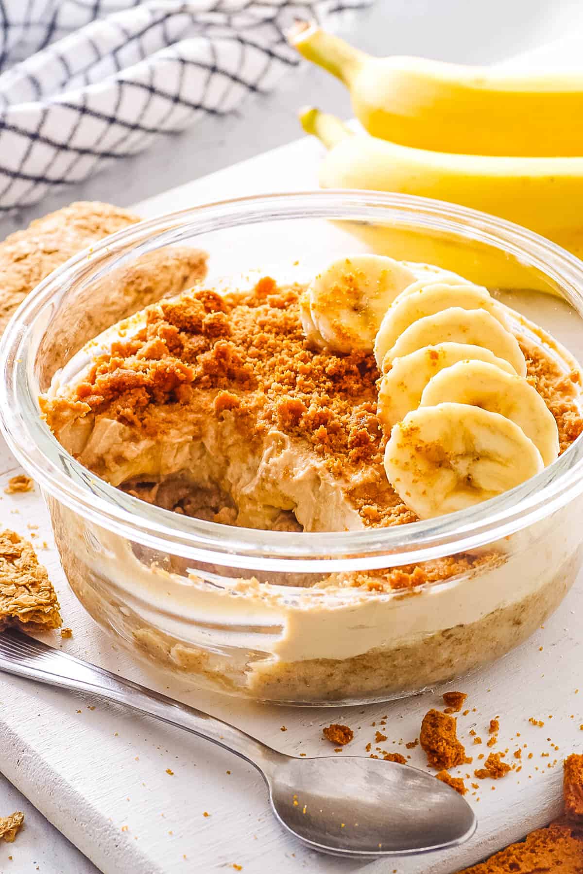 Easy overnight Weetabix, topped with sliced bananas, served in a gl، bowl.