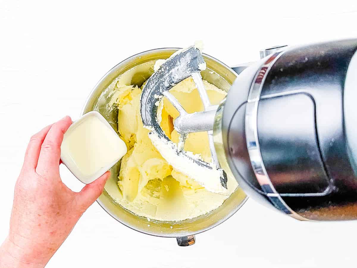 Vanilla buttercream frosting being mixed in the bowl of a stand mixer.