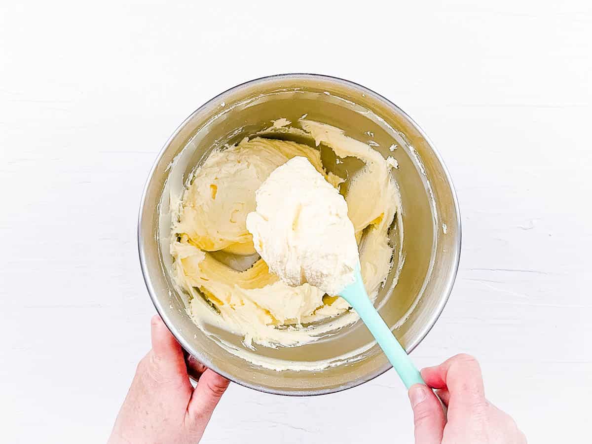 Cupcake frosting being mixed in a mixing bowl.