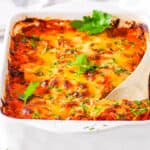 Healthy baked spaghetti squash casserole, in a casserole dish topped with fresh herbs.