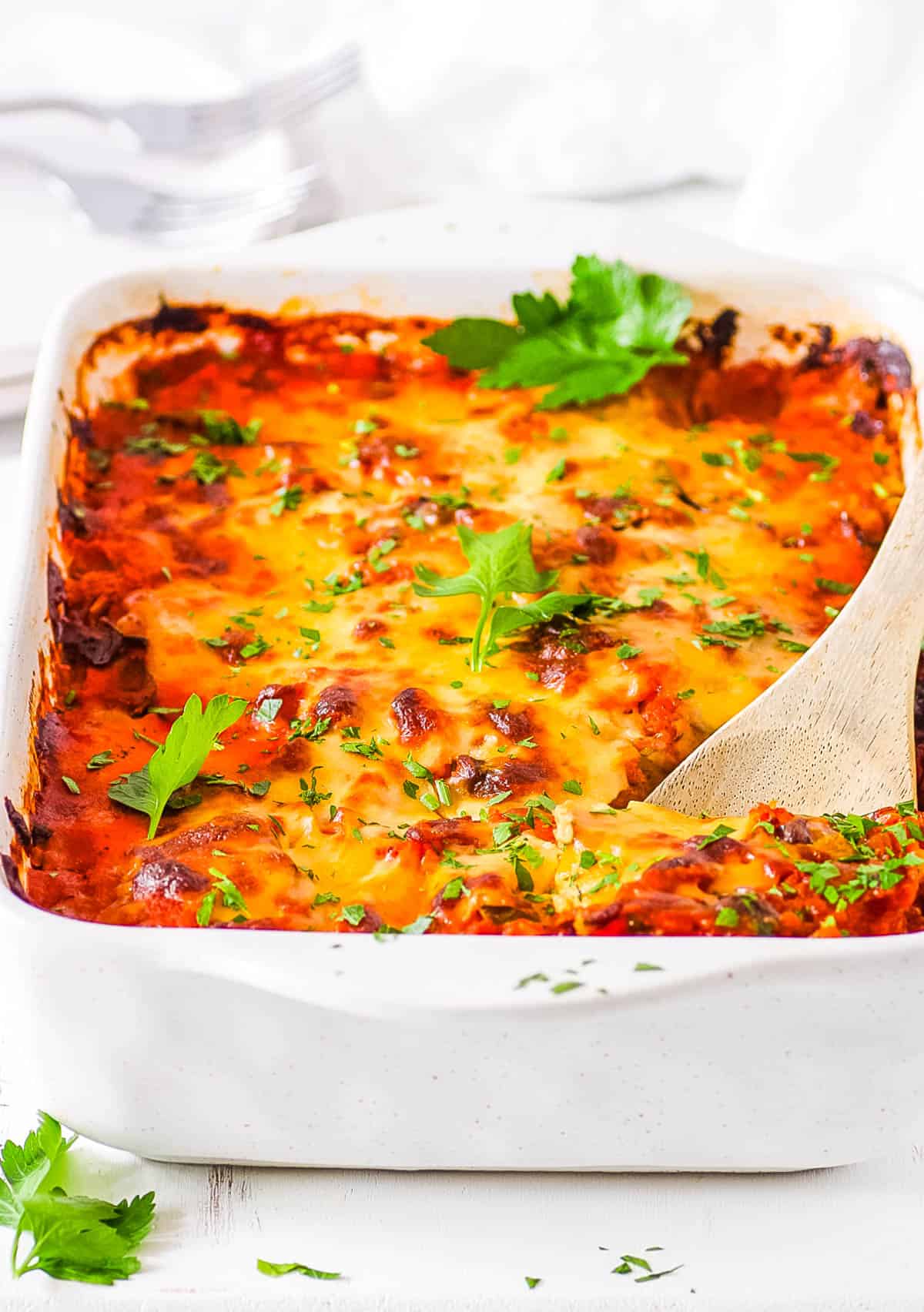Healthy baked spaghetti squash casserole, in a casserole dish topped with fresh herbs.