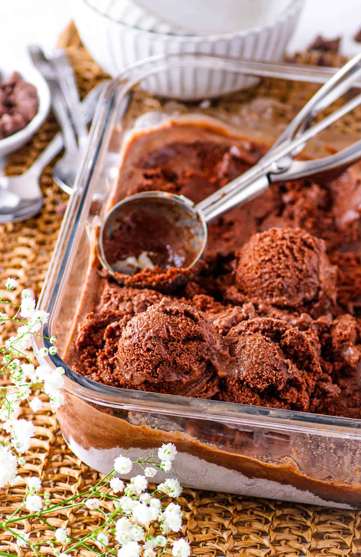 Scoops of chocolate tofu ice cream on top of chocolate ice cream in a glass serving dish.