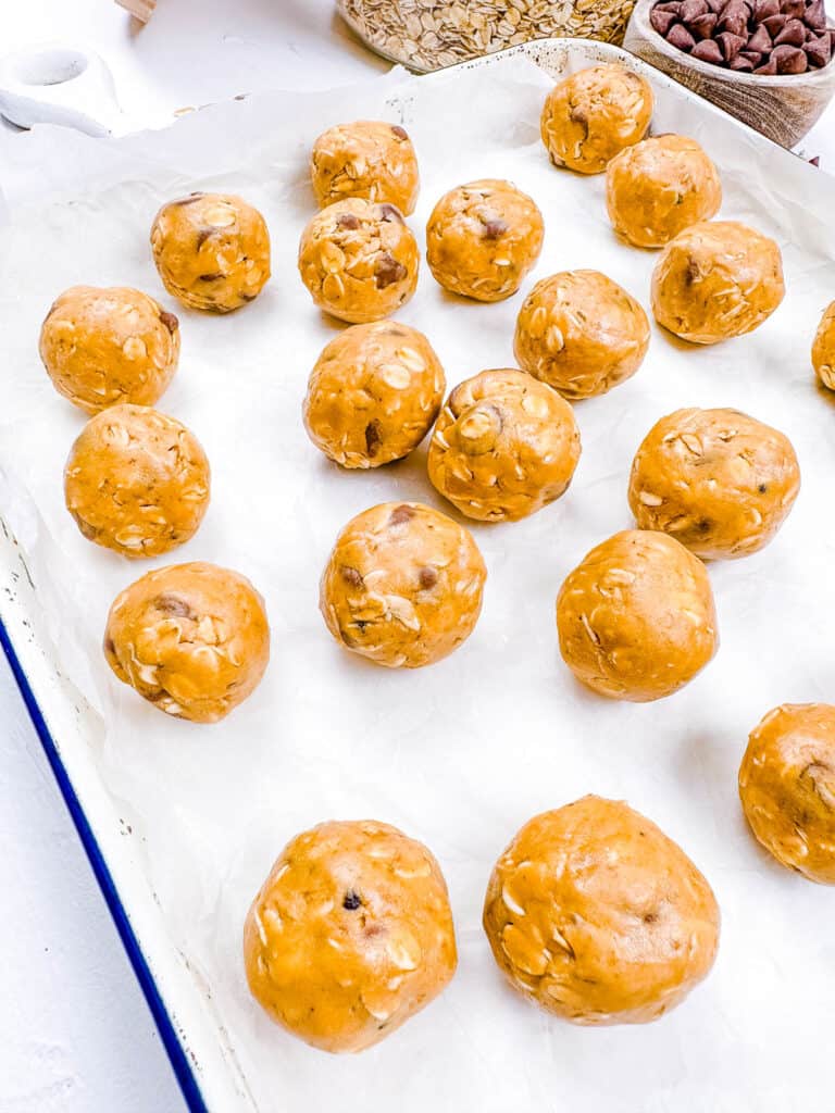 Vegan energy bites on a baking sheet lined with parchment paper.