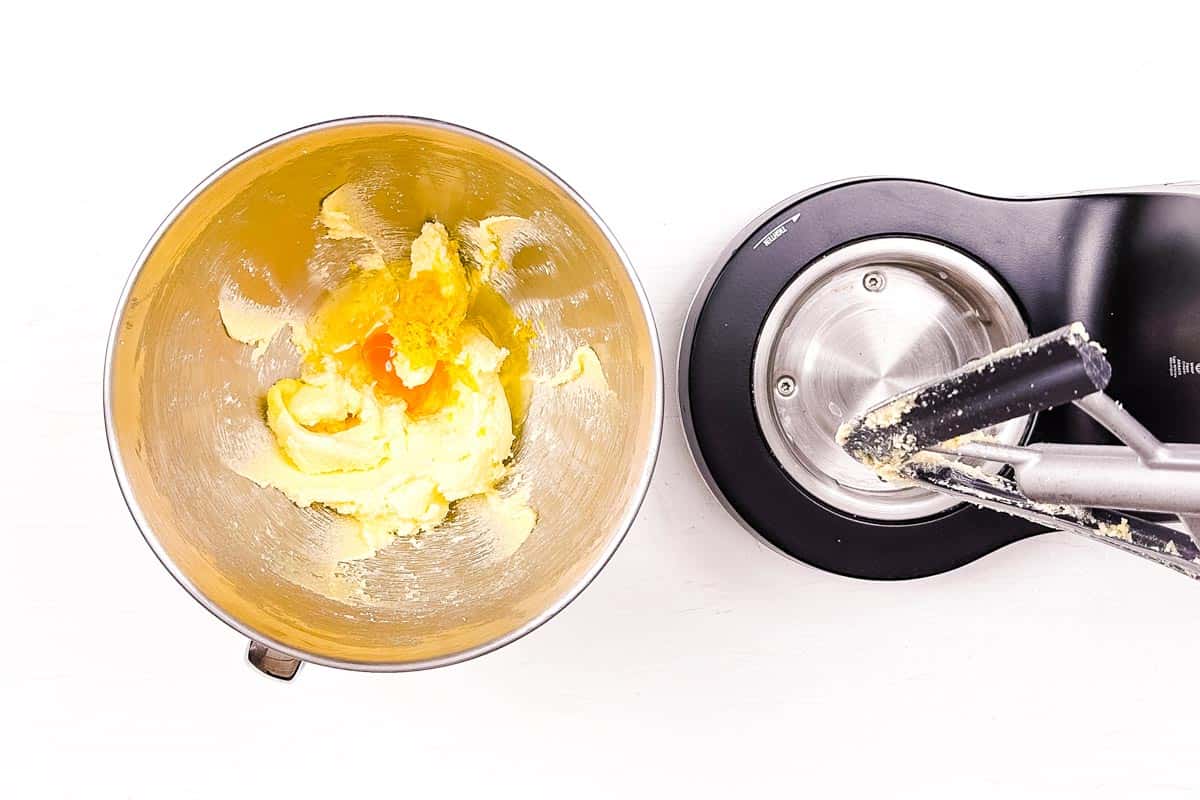 Adding lemon juice, lemon zest and egg to the creamed butter sugar in the bowl of the stand mixer.