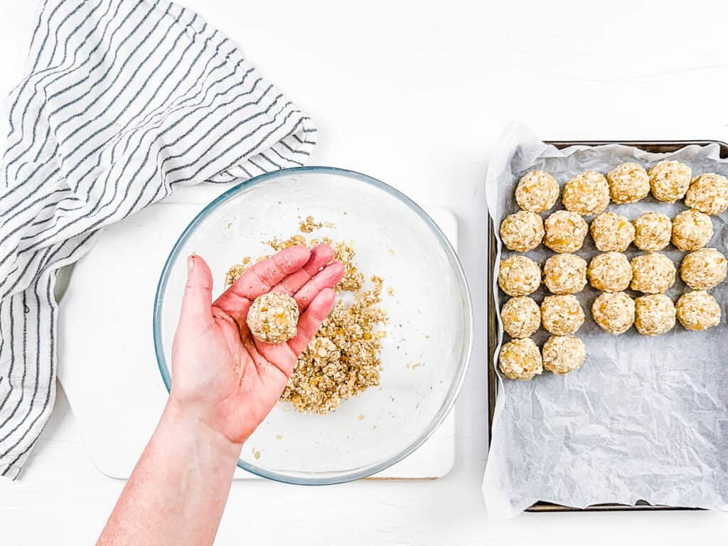 Tofu ball rolled in a hand over a mixing bowl.