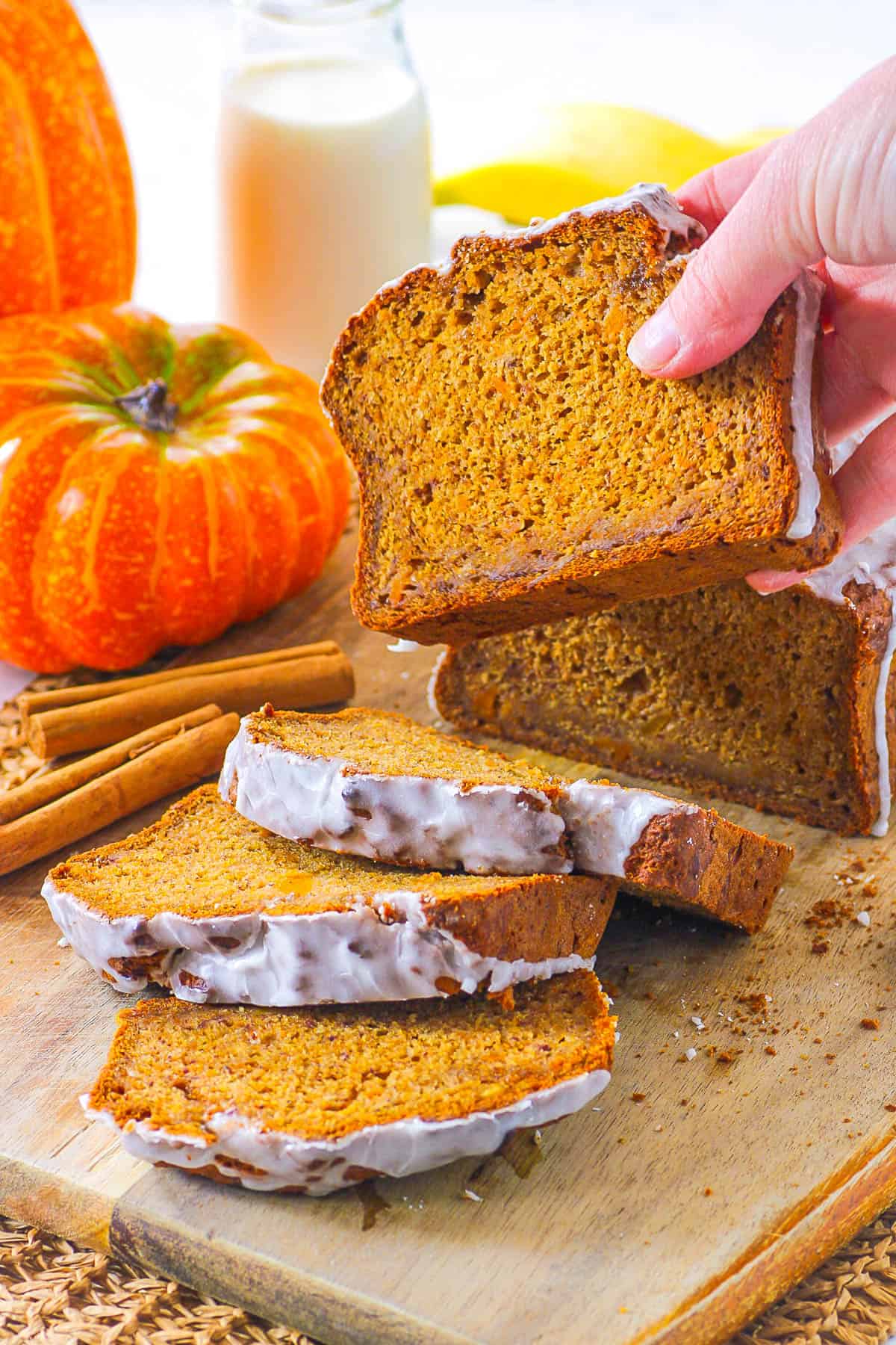 Slice of vegan pumpkin banana bread being held up by a hand.