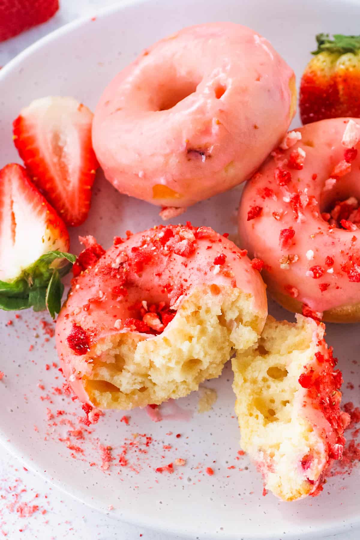 Easy strawberry donuts with a strawberry glaze, served on a white plate.