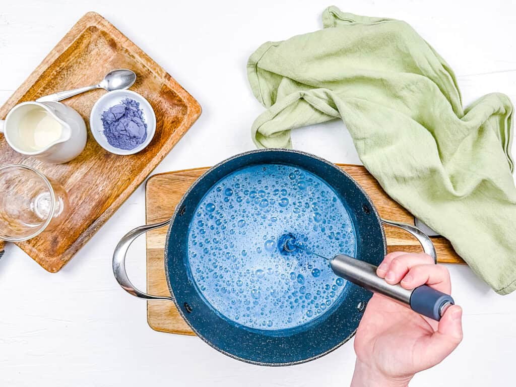 Butterfly pea flower latte being mixed in a pot.