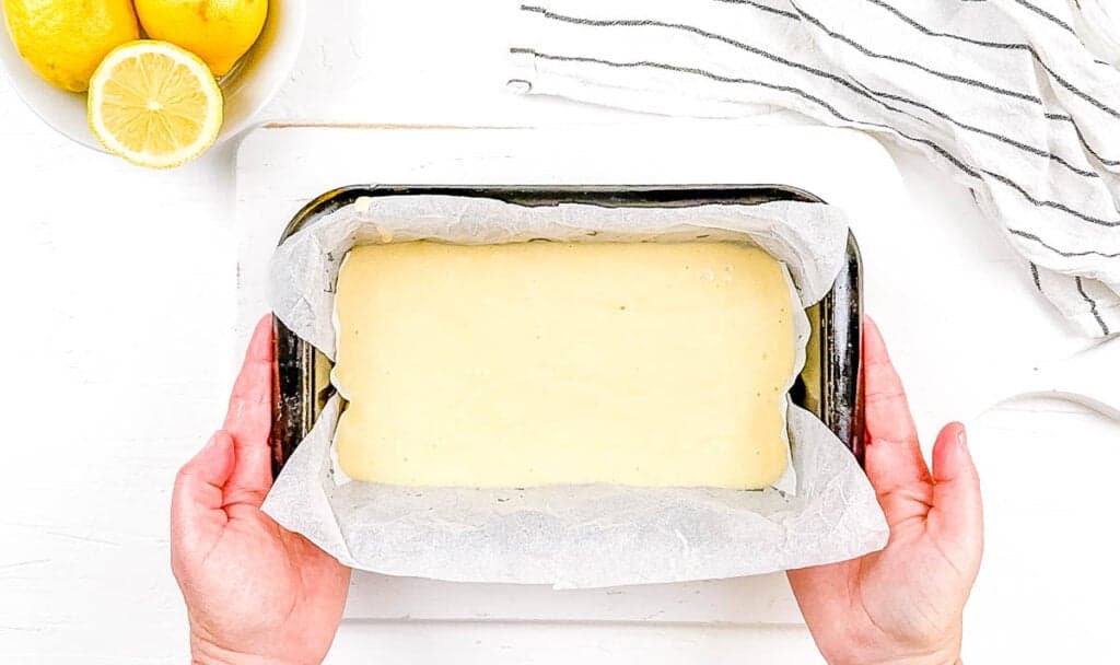 Vegan cake batter in a baking dish lined with parchment paper.