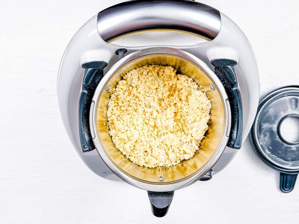Pie crust ingredients being blended in a food processor.